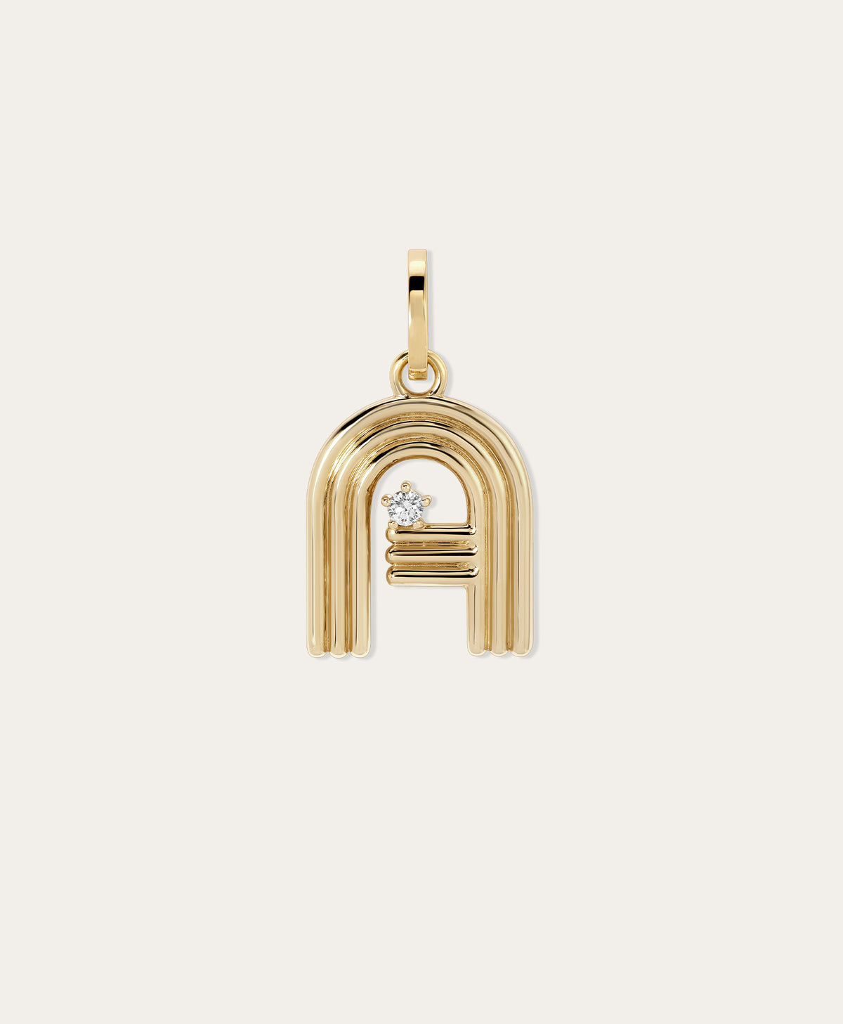 Gold Groovy initial pendant with a diamond on a neutral background.