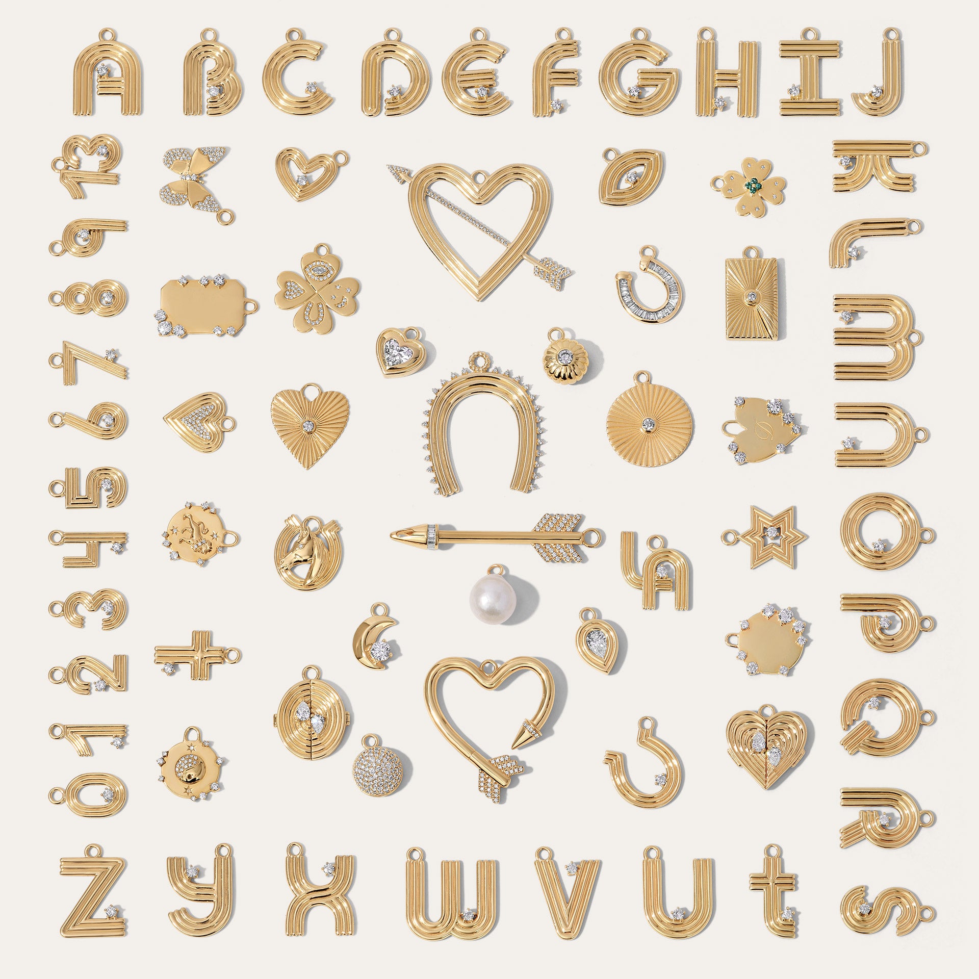 An assortment of various gold charms with diamonds including hearts, flowers, letters in A-Z, clovers, evil eyes horseshoes, a moon, and zodiacs.