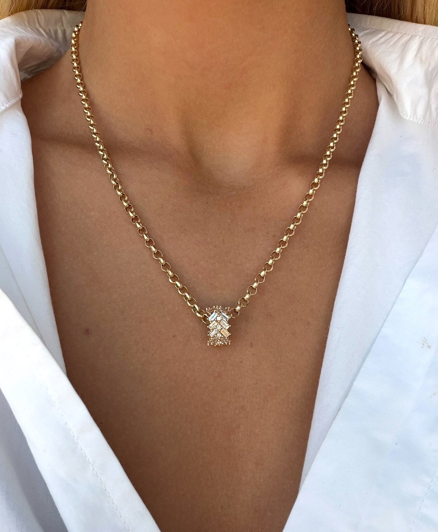 A gold chain necklace with diamond big bead pendant, worn by a model in a white collared shirt.