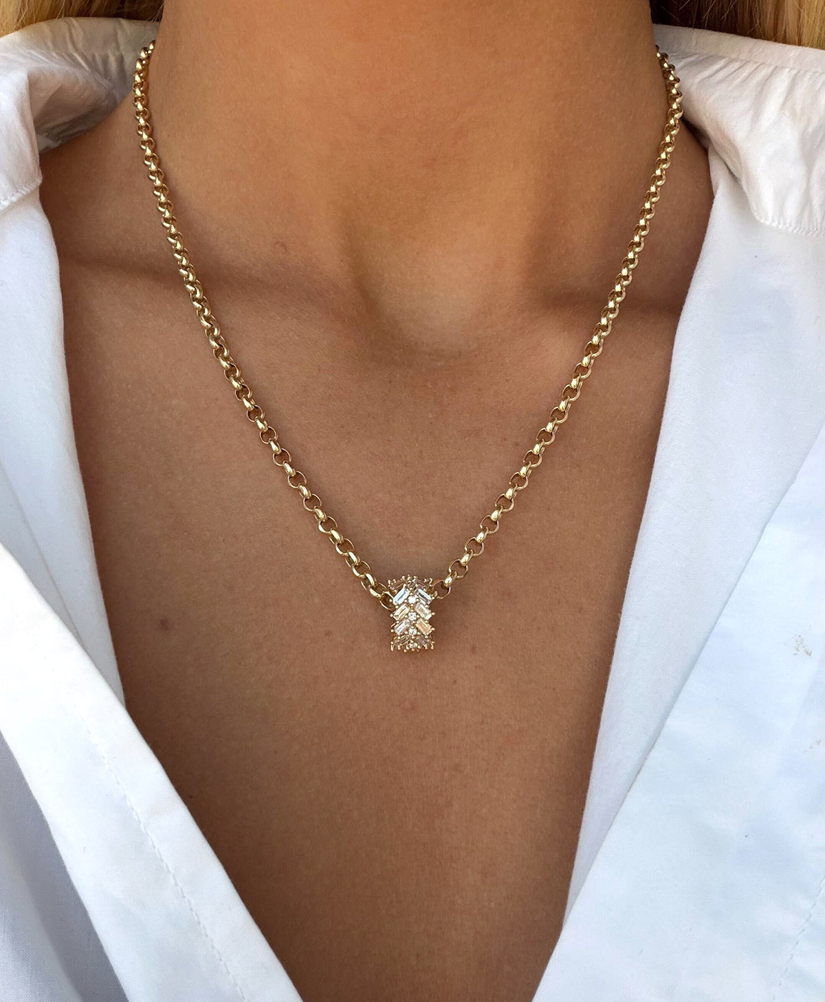 A gold chain necklace with diamond big bead pendant, worn by a model in a white collared shirt.